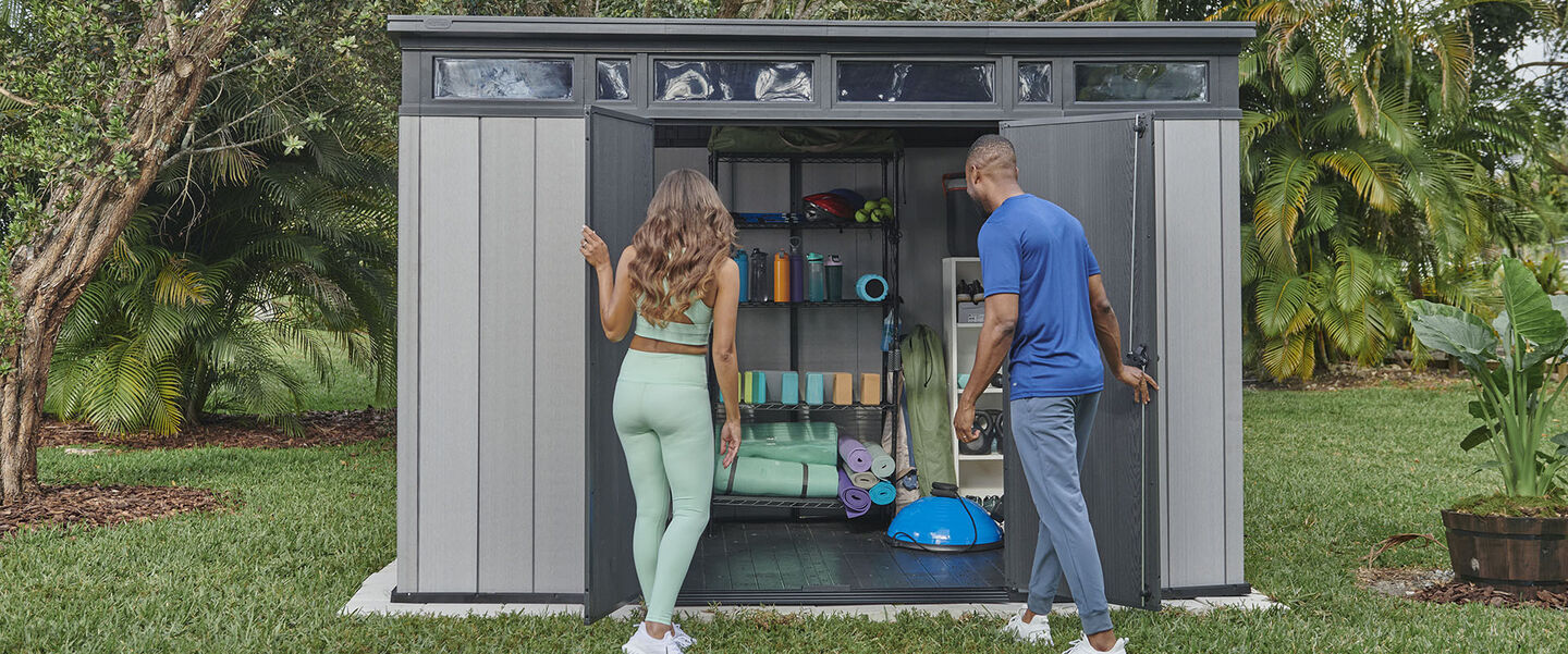 Couple grabbing work out equipment from an outdoor shed