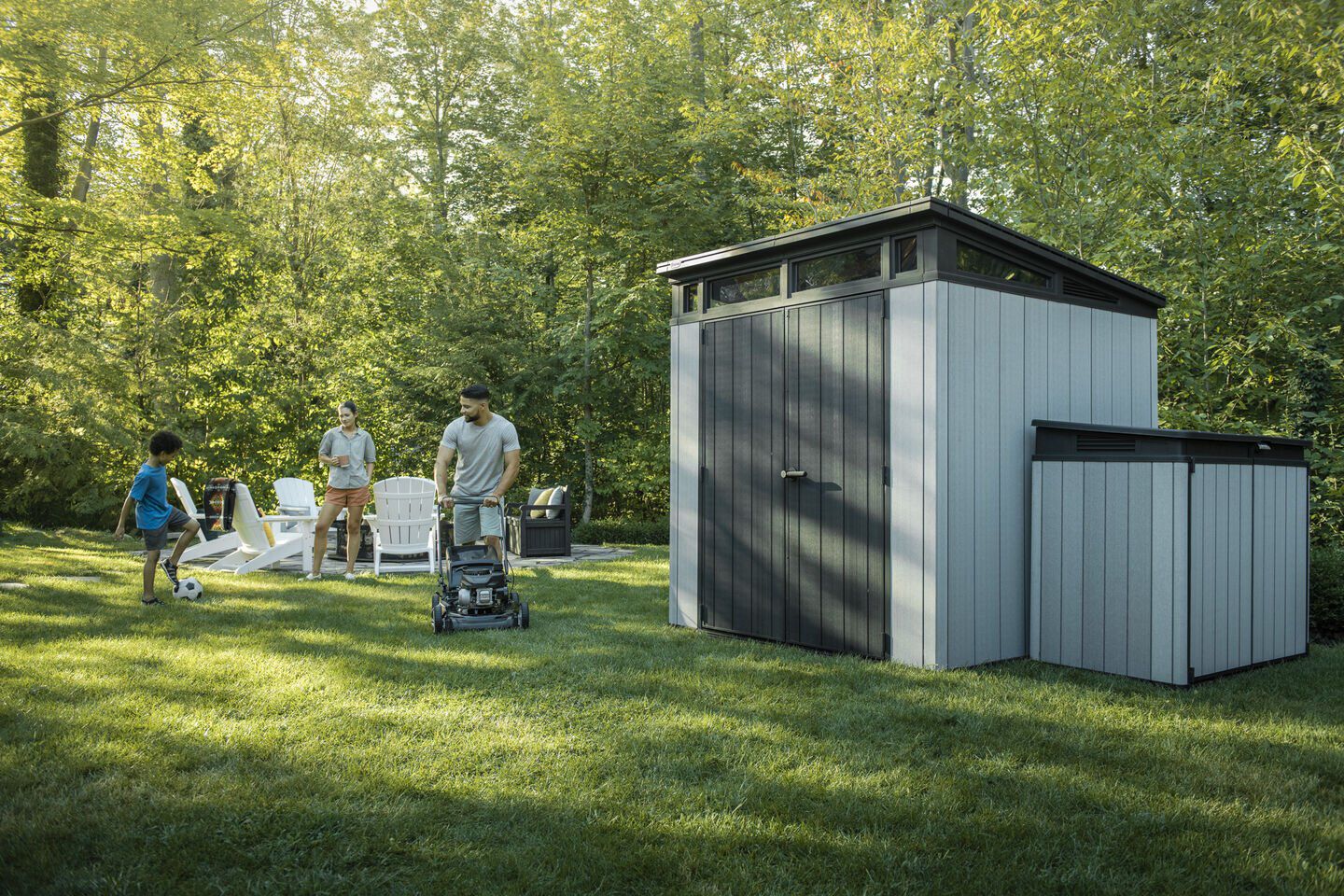 Man mowing the grass around his storage sheds