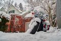 Motorcycle outside a house covered in snow