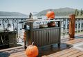 Man and woman grab a drink together form their Keter Unity XL kitchen cart while outside during a party 