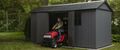 Man pushing lawn mower out of storage shed