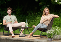 Man and woman enjoy a coffee together on their balcony while sitting in their Keter  RIO outdoor furniture set