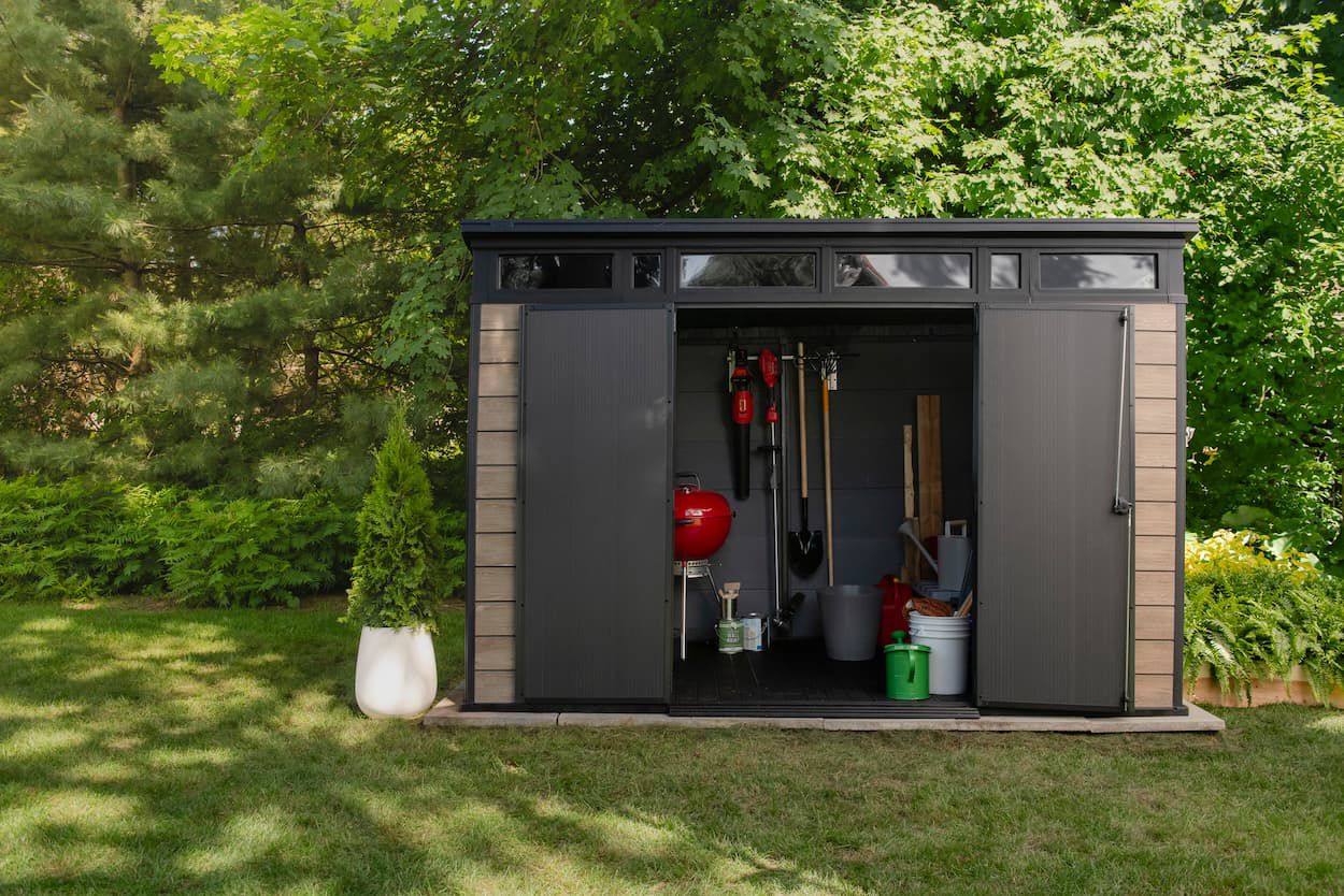 Open door signature shed with backyard items inside